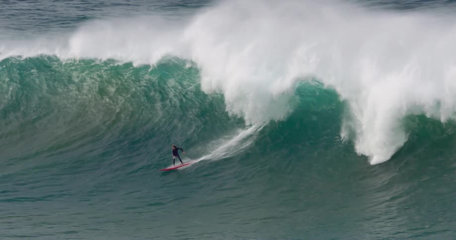 A group of people are riding a large wave in the ocean
