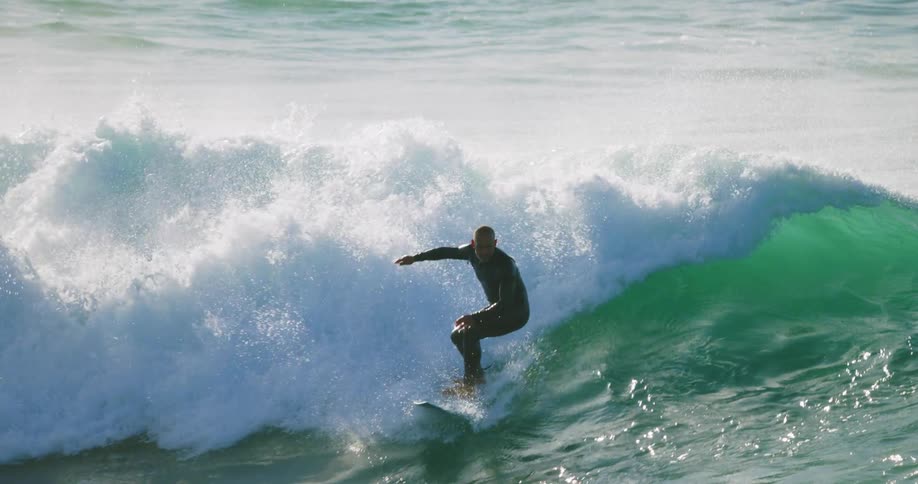 A man surfing on a surfboard in the ocean on a wave