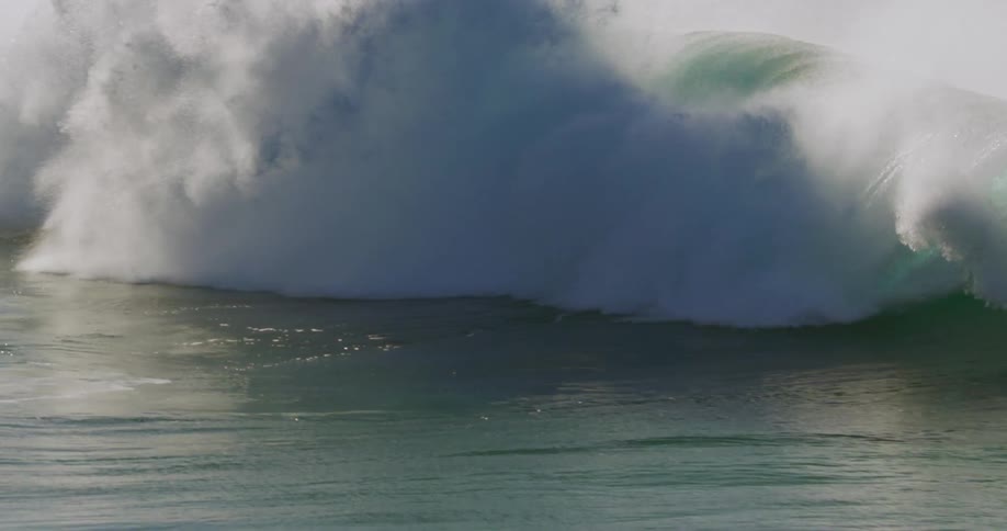 A surfer wipes out on a huge ocean wave