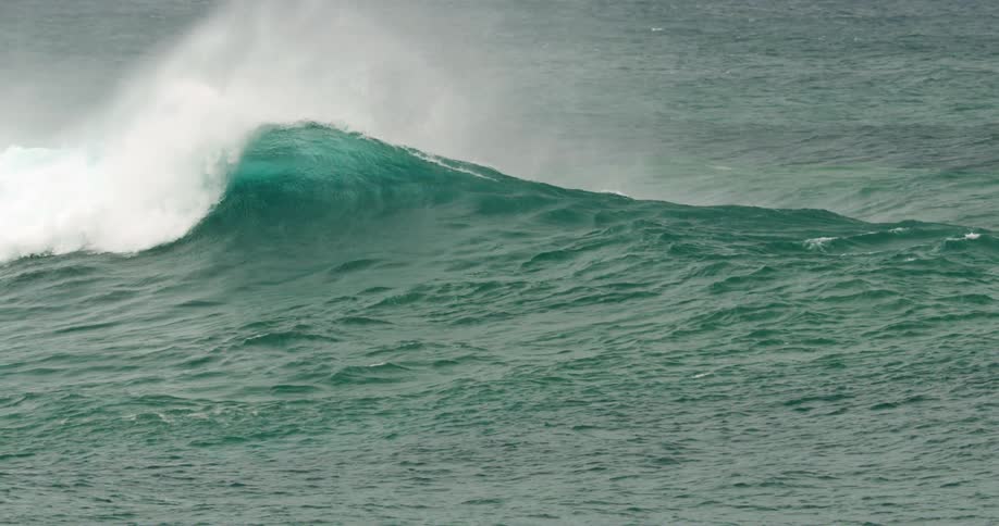 The large wave folds over and crashes