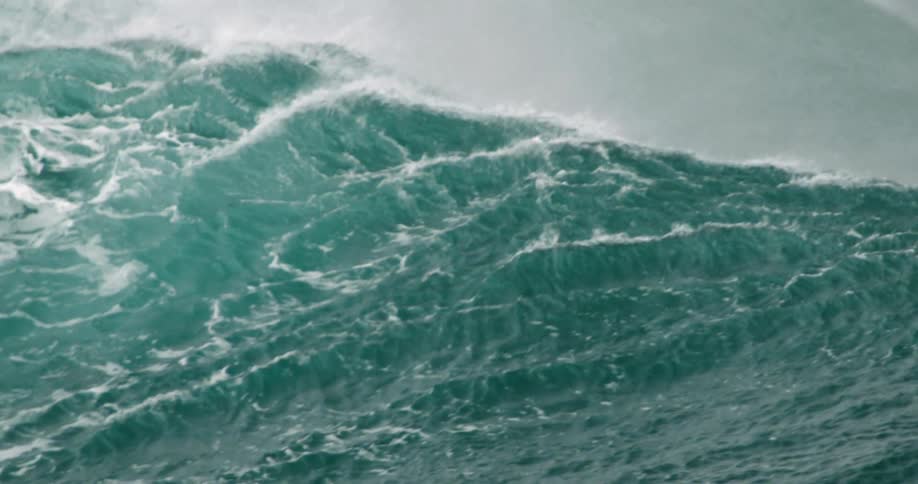 An ocean wave curls and splashes as it breaks