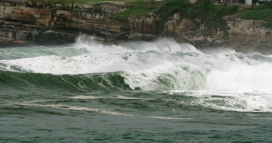 The large waves crash against the coast