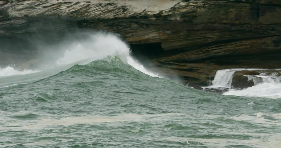 The ocean with water and waves with a rocky shore in the background