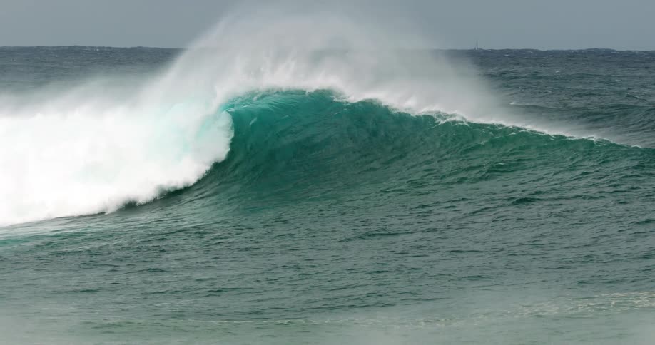 A bluegreen wave rolling in the ocean during the day