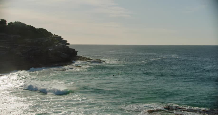 Waves coming in to shore under red skies