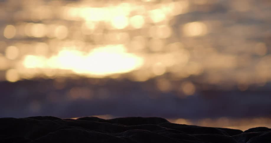 Sun reflects of waves flowing onto beach