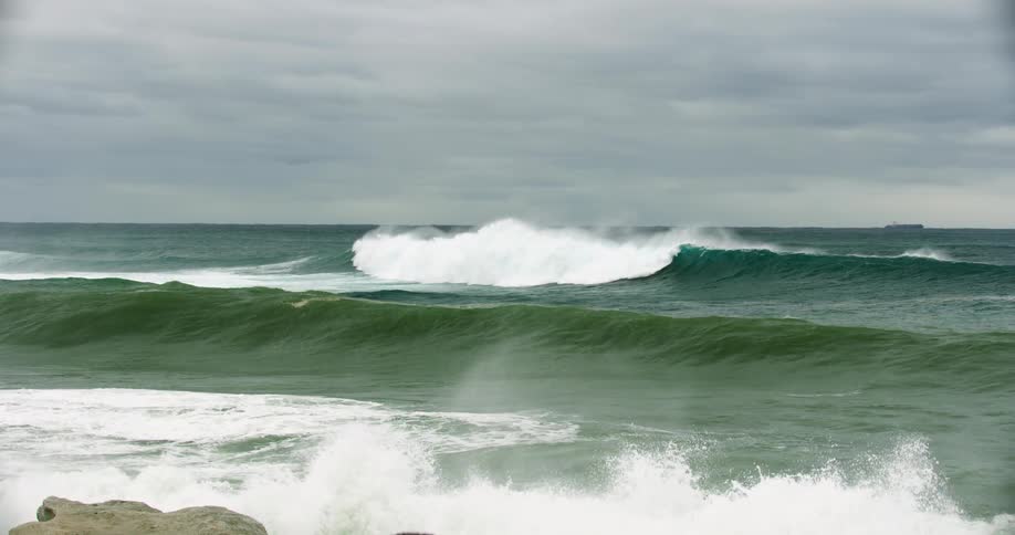 The large waves hit the rocky shore