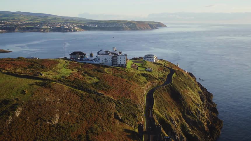 Aerial view of a road on a hill next to the ocean