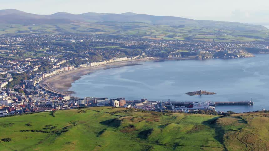 A bay surrounded by the buildings of a city and hilly countryside