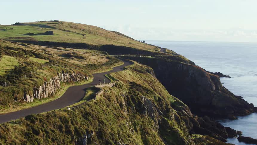 Two people hike on the trail by the shore