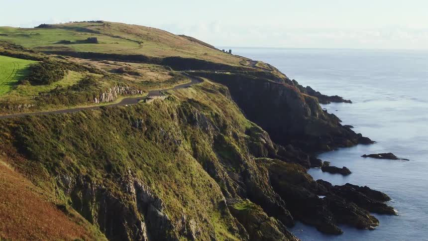 A country road follows the curves of the cliff it sits on