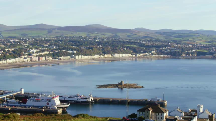 Several ships are docked in a bay with a city along the shoreline