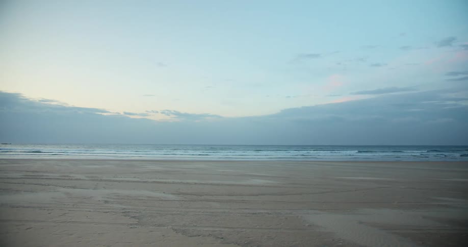 Gentle waves washing onto the sands of a beach during the day