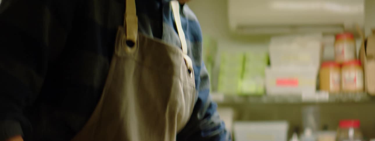 A chef cutting an onion on a plastic cutting board in a commercial kitchen