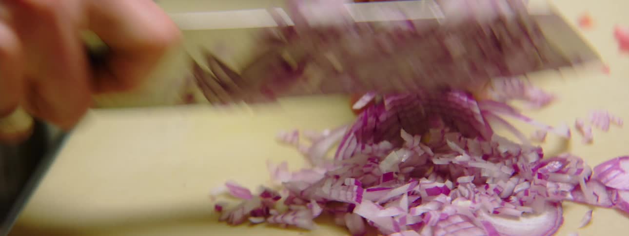 Man in an apron chopping onions