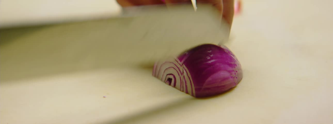 A person slices an onion