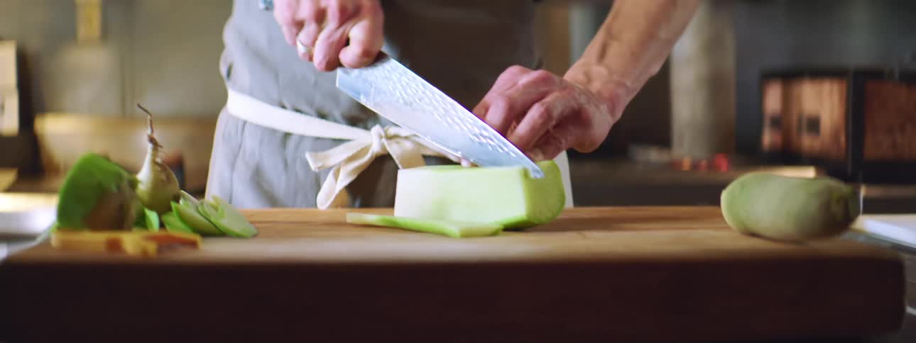 Man chops vegetables in kitchen