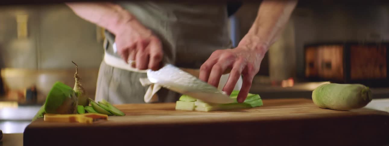 A man chops vegetables on a cutting board