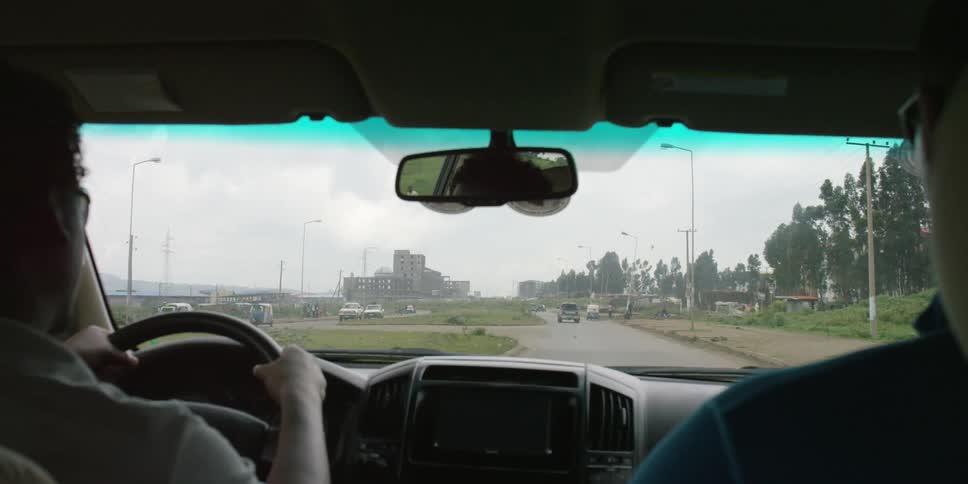 A man is driving his car during the day