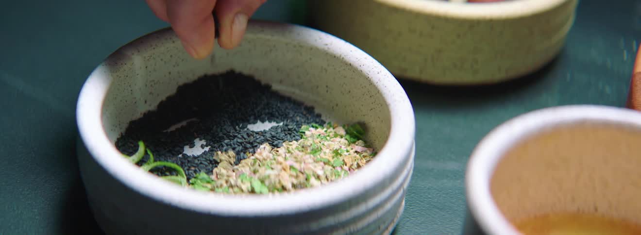 A person taking spice out of a bowl