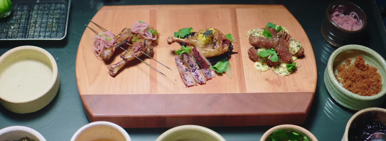Exotic food served on a board surrounded by bowls of spices