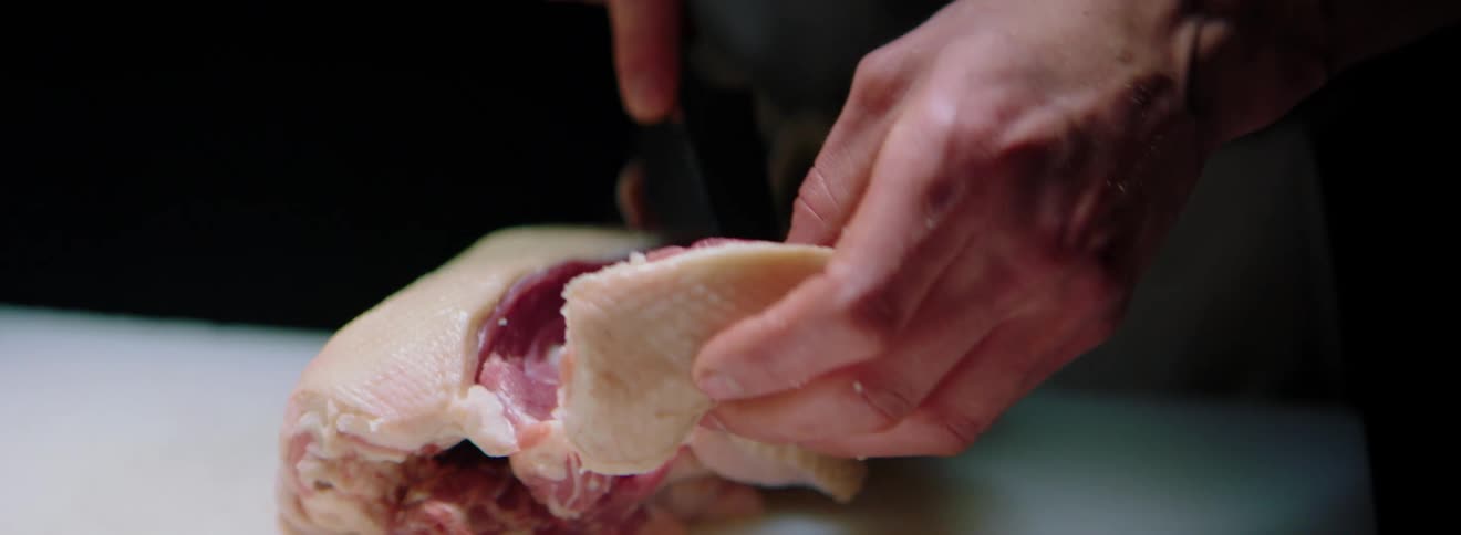 A person cuts into poultry