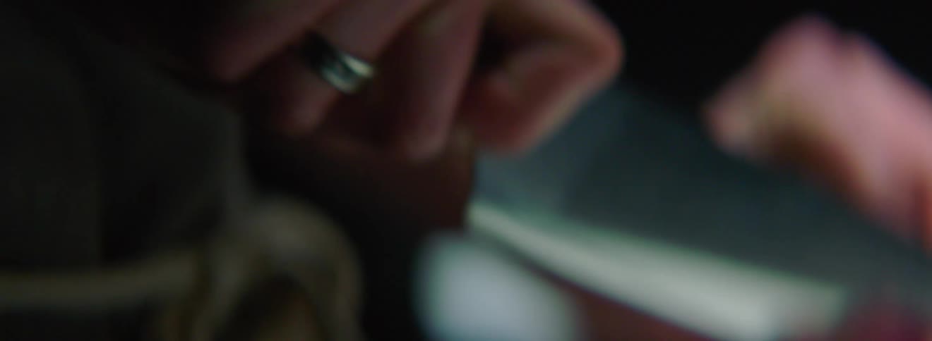 A person is using a sharp knife in their right hand to chop food on a cutting board