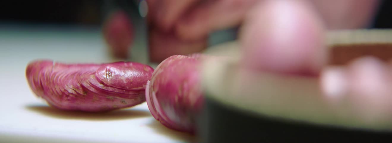 Food being cut with a knife on a white table