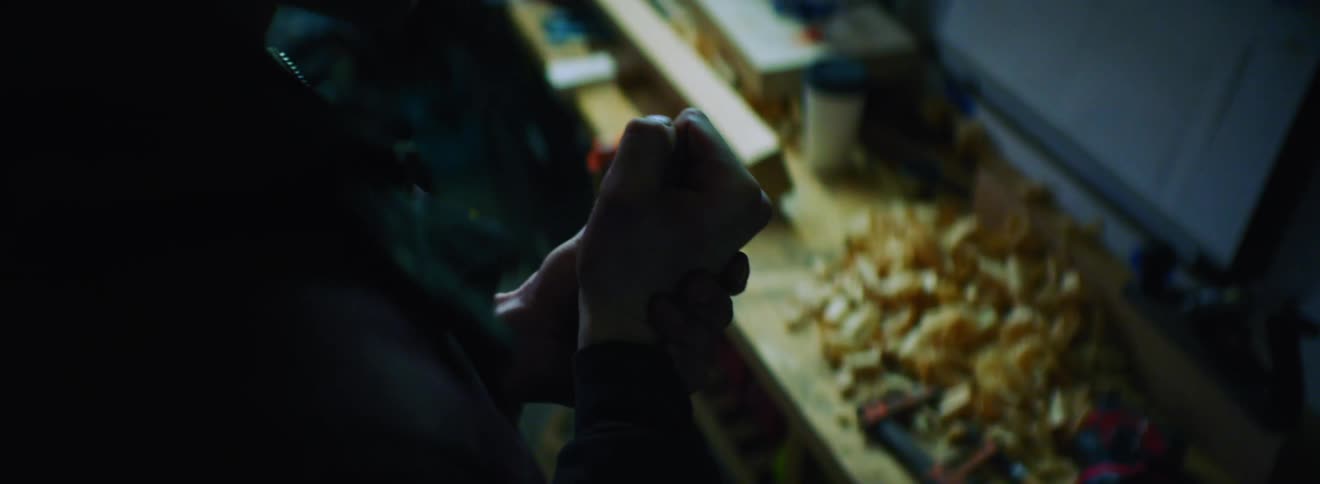 A person in a workshop examining and stretching their hands