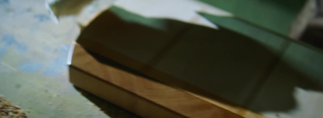A liquid being rubbed on a wooden board with a cloth