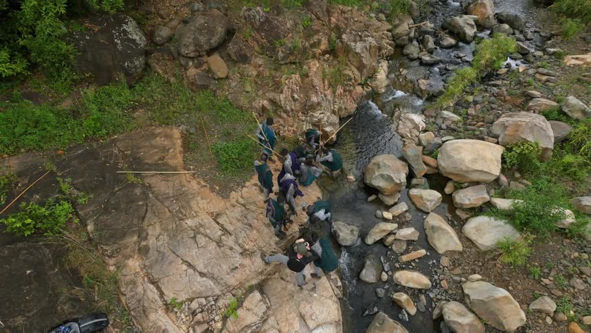 Aerial view of a village people standing by a stream