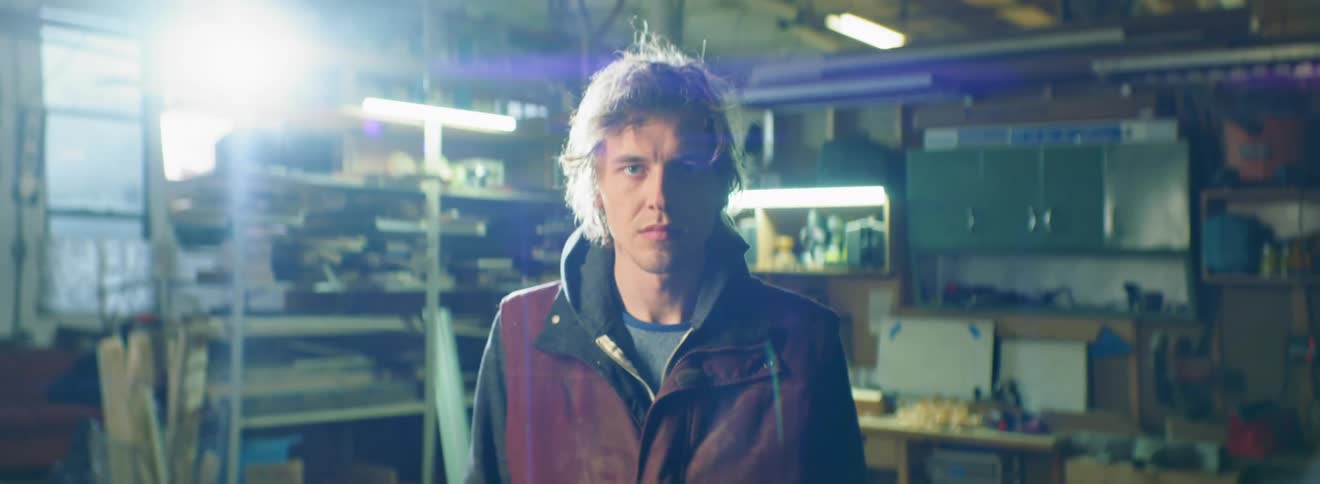 Man looks ahead while standing in dark garage