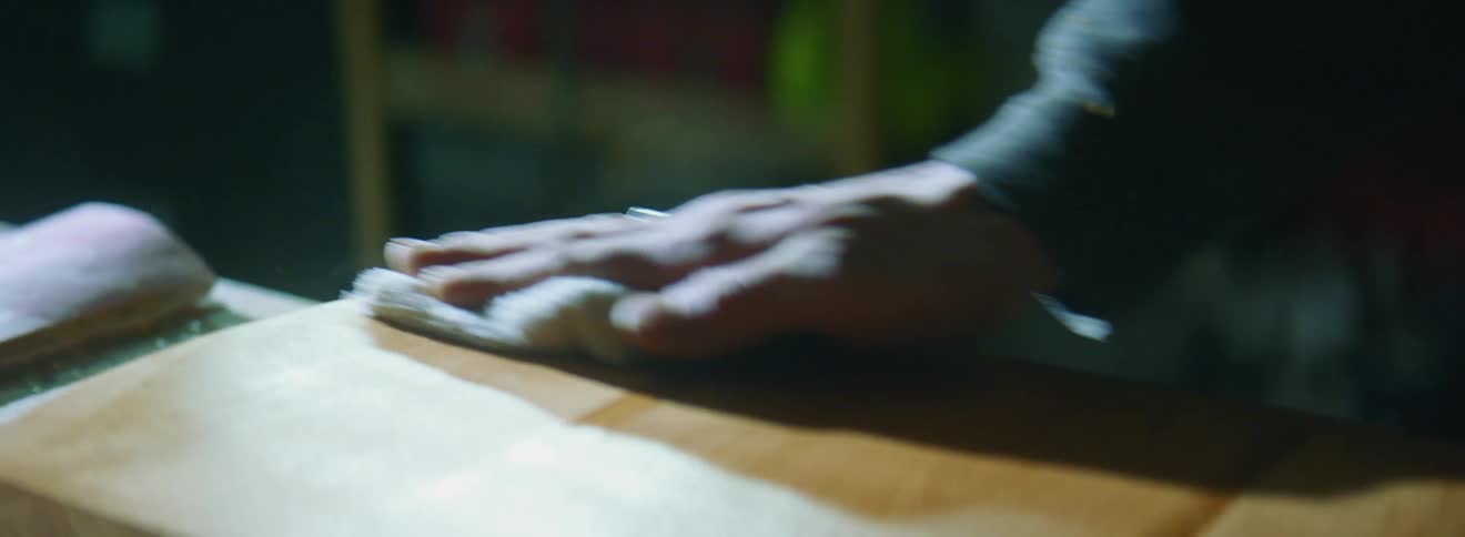 A person cleans off a cutting board