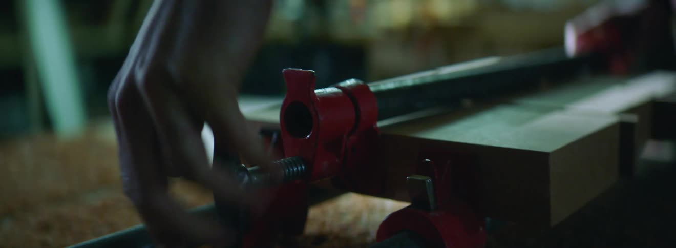 A woodworker uses a chop saw to cut a piece of wood