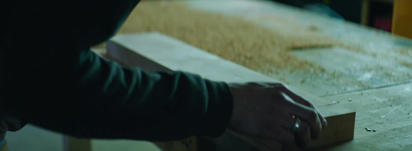 Man examines board in workshop