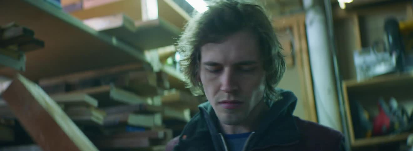 A young man examines a piece of wood