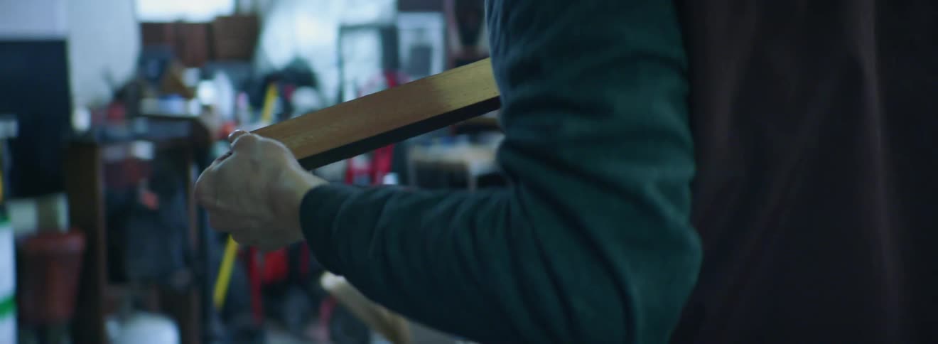 A person inspects a piece of wood