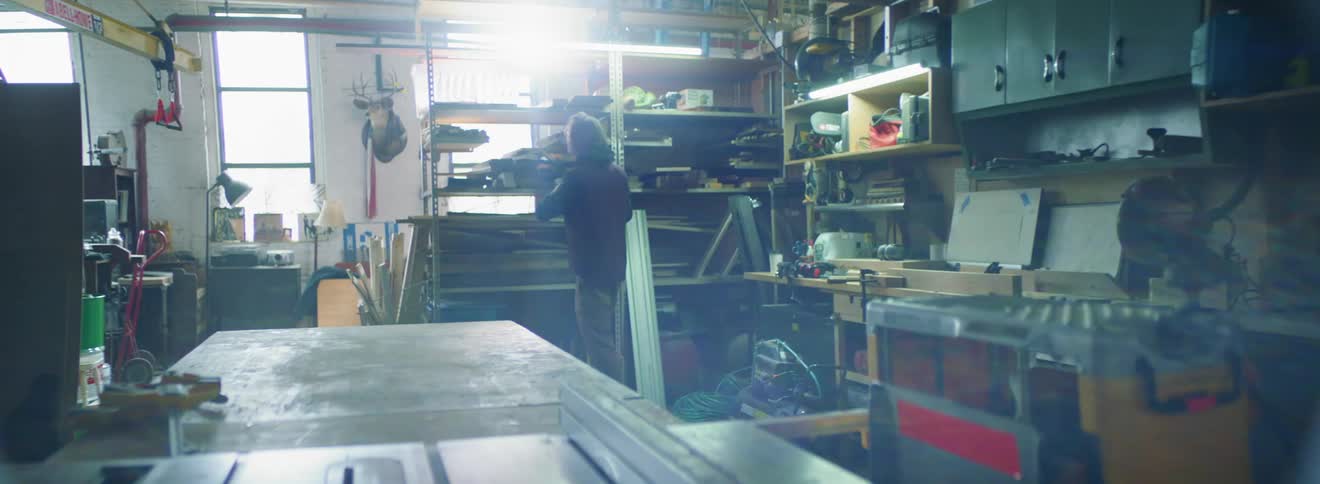 A person looking through items on a garage shelf