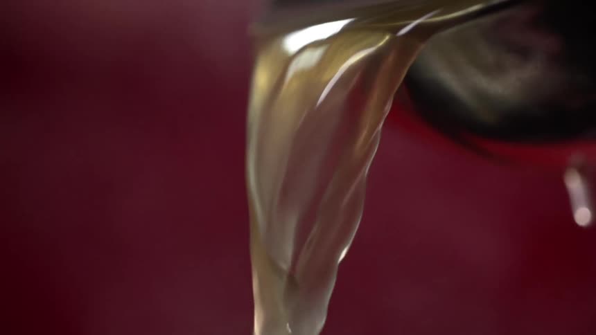 Steaming hot broth pouring out of a metal bowl