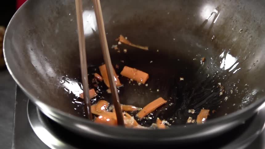 Carrots being stir fried in a wok