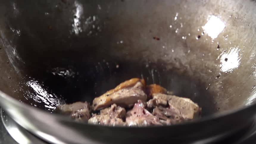 The steak is being cooked in the wok