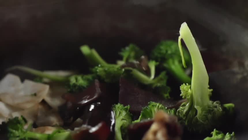 Food falling on to a plate of broccoli