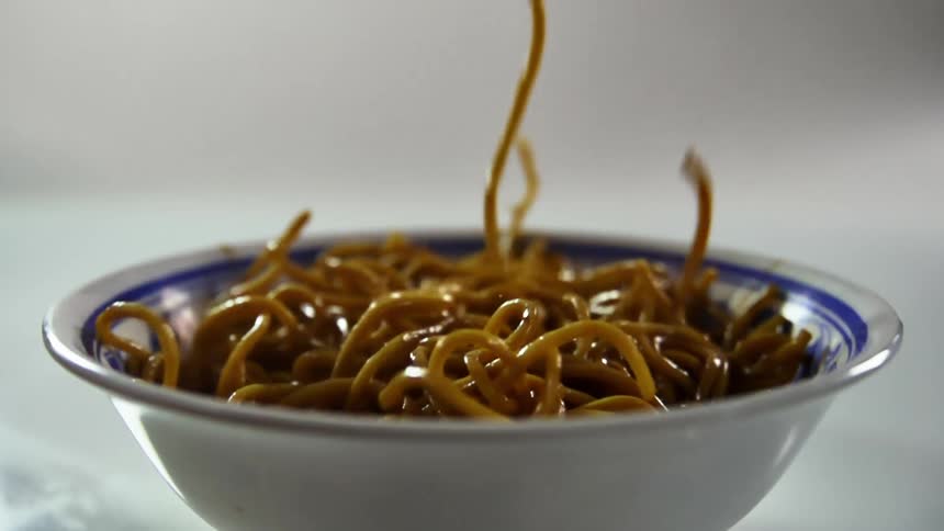 Noodles falling in to a bowl
