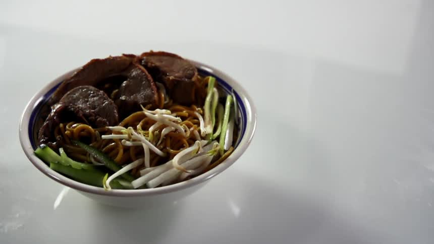 Bean sprouts dropping in a bowl of food for a photo shoot
