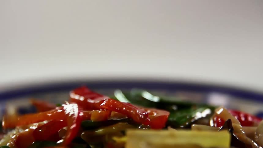 Peppers falling in to a dish of food for a photo shoot