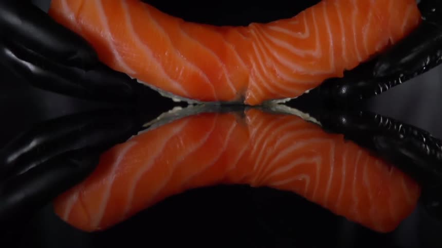 A salmon filet is placed skin side down on a black counter