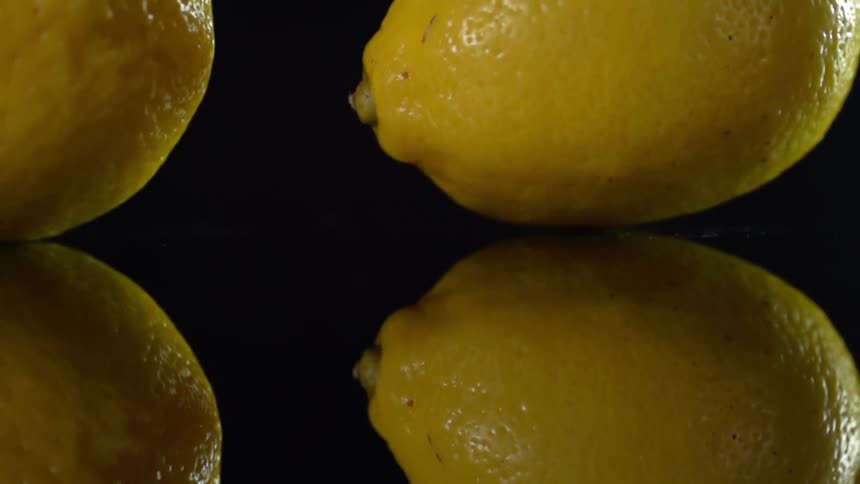 Lemon swaying in slow motion on a reflective counter top