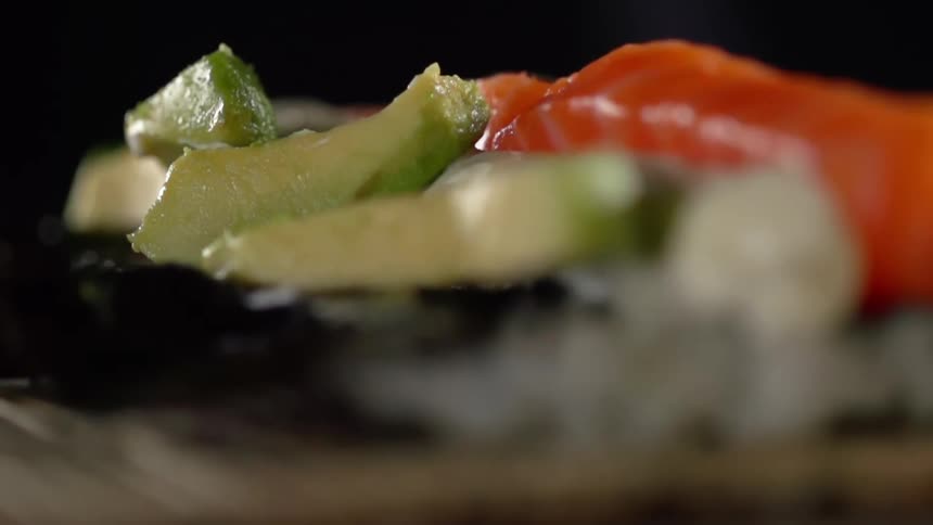 Avocado being dropped on top of fish