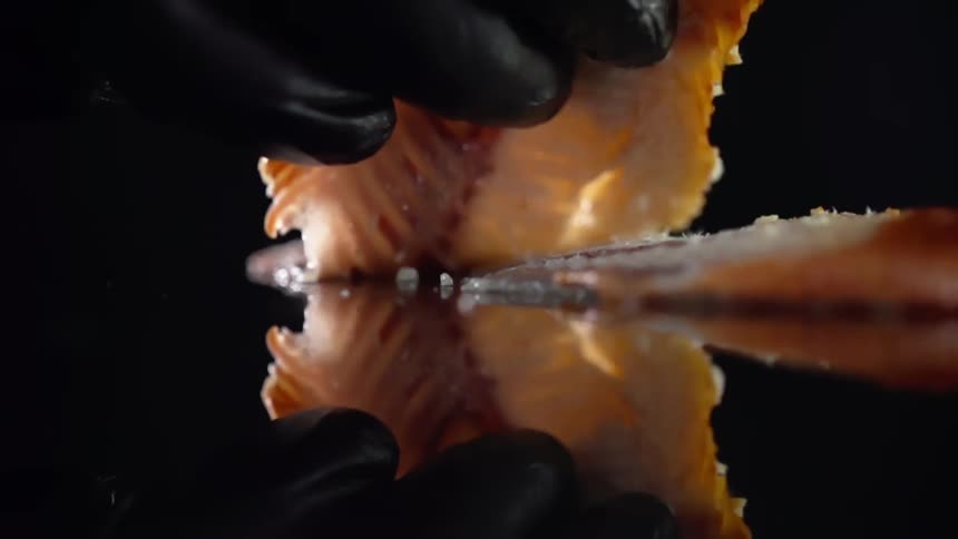 A person picks up a piece of fish