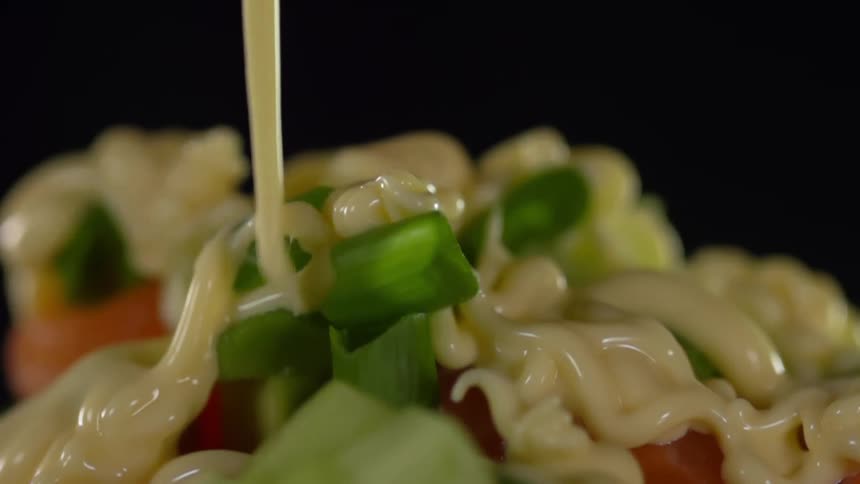 Thick white dressing is added to a salad